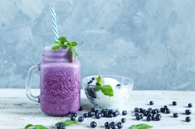Yaban mersini smoothies dondurma, nane ve gri bir arka plan kopya alanı üzerinde çilek ile.