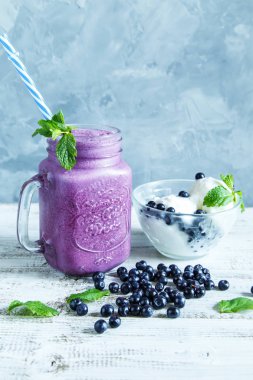 Yaban mersini smoothies dondurma, nane ve gri bir arka plan kopya alanı üzerinde çilek ile.