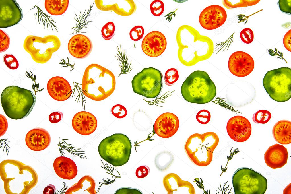 Collection of sliced vegetables and herbs on a white background.
