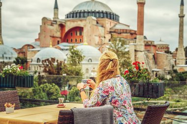 Kız Türk kahvesi Ayasofya Müzesi manzarayı içecekler. Istanbul, Türkiye.