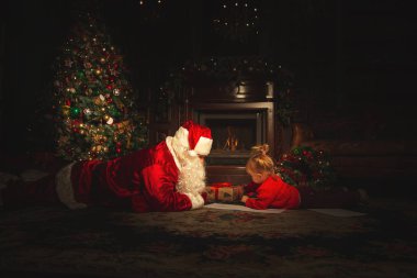 Gerçek Noel Baba ile çocuklar Noel ağacı yakın oynuyor. Atmosfer kutlama ve büyü.