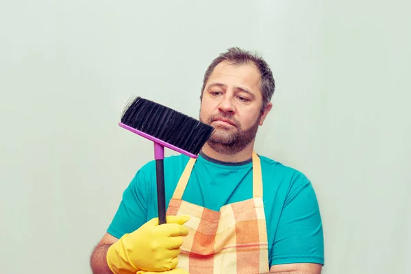 Emotionele Bebaarde Man Houdt Een Bezem Lichte Achtergrond — Stockfoto