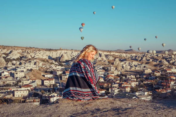 Girl at dawn watching the balloons and enjoying life. Cappadocia, Goreme, Turkey - September 24, 2018.