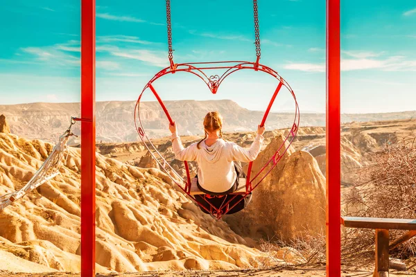 ブランコに乗っている屈託のない女性。感動の山の風景. — ストック写真
