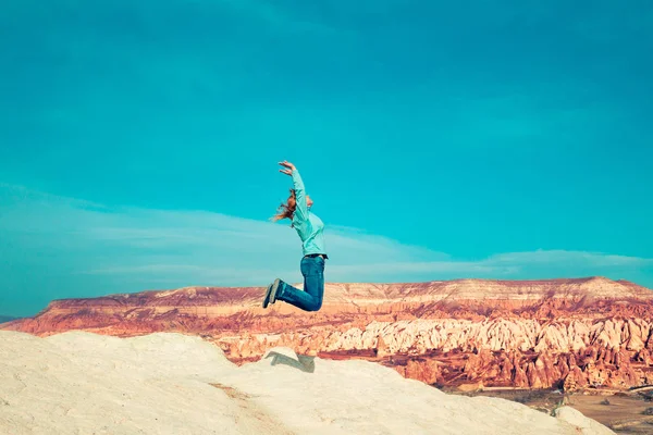 Chica saltando en el fondo de un paisaje de montaña . —  Fotos de Stock