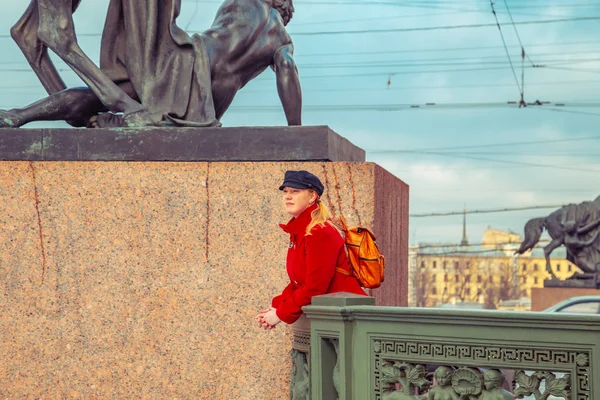 Blonde en manteau rouge se promène le long du remblai de la Fontanka — Photo