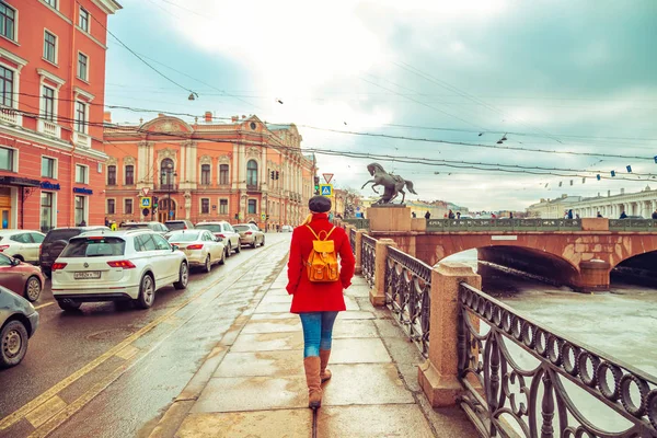 Ξανθιά σε ένα κόκκινο παλτό περπατά κατά μήκος το ανάχωμα του Φοντάνκα το — Φωτογραφία Αρχείου