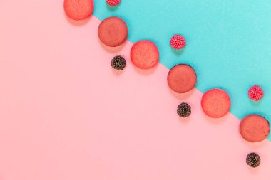 Pembe ve mavi arka planda macaroons ve çilek. Geometrik p