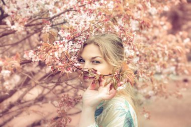 Bahar bahçesinde güzel sarışın kız.