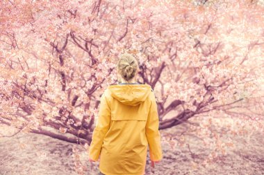 Bahar bahçesinde güzel sarışın kız.