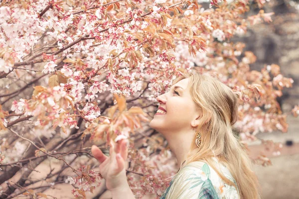 Krásná blondýnka v jarní zahradě. — Stock fotografie