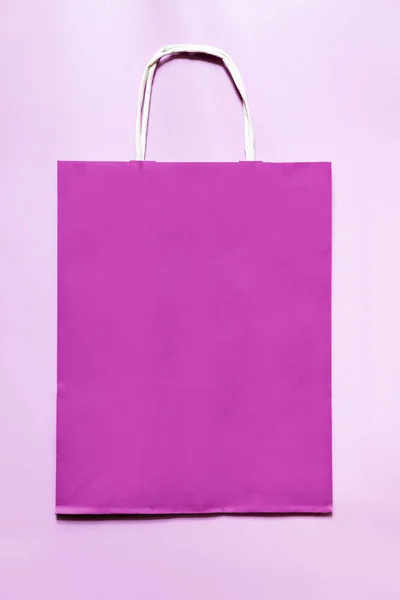 Fialový papírový sáček na růžovém pozadí. — Stock fotografie