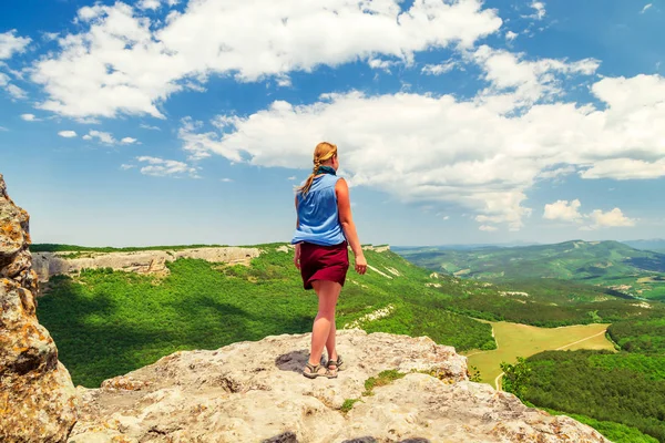 Hiker girl se para en la cima de una montaña . —  Fotos de Stock