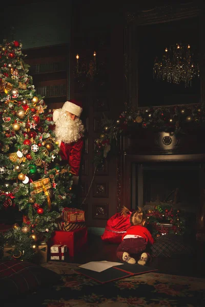 Los niños juegan cerca del árbol de Navidad. El verdadero Santa Claus es w — Foto de Stock