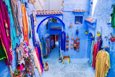 Mavi Chefchaouen sokakta geleneksel halılar. 