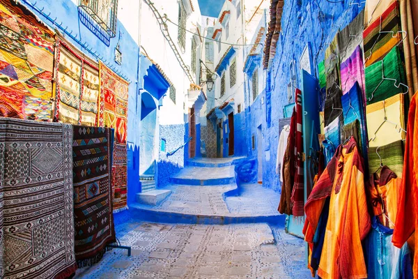 Mavi Chefchaouen sokakta geleneksel halılar. 