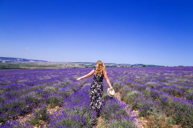 Lavanta tarlasındaki kız. Kırım'da güneşli bir yaz günü. Mutluluk ve özgürlük kavramı.