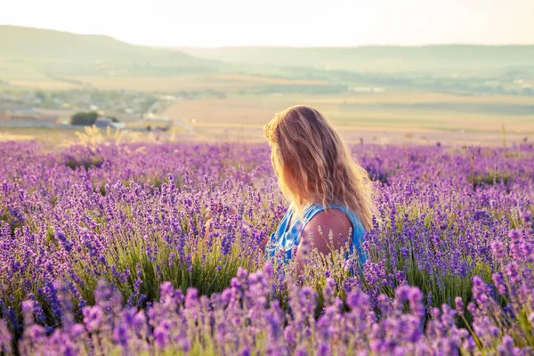 Girl in a lavender field at sunset. Sunny summer evening in Crimea. The concept of happiness and freedom.