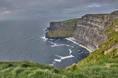 İrlanda 'nın Moher Kayalıkları' nın panoramik manzarası. Günbatımında Moher Kayalıkları. İrlanda 'nın kıyı şeridinde büyük uçurumlar var. Anne kayalıklarında gün batımı.