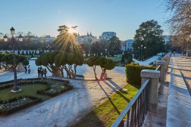 Madrid, İspanya 'daki emeklilik parkında gün batımı. Gün batımında park emekliliği. Emeklilik parkının panoramik manzarası. Arkasında ağaçlar var..