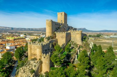İspanya 'da kırmızı çatı evlerinin dairesel halkasıyla çevrili platodan yükselen donjon ve avlu ortaçağ Almansa kalesinin havadan görünüşü, ünlü bir savaş alanı.