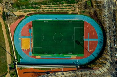 Gökyüzü manzaralı mavi atletik rayları olan renkli bir stadyum