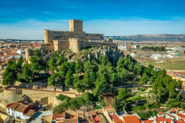 İspanya 'da kırmızı çatı evlerinin dairesel halkasıyla çevrili platodan yükselen donjon ve avlu ortaçağ Almansa kalesinin havadan görünüşü, ünlü bir savaş alanı.