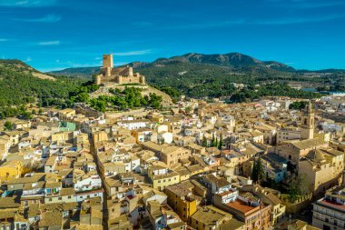 İspanya 'nın Valensiya eyaletindeki Biar Kalesi' nin havadan görünüşü. Donjon şehrin üzerinde yükseliyor ve mavi gökyüzü olan güneşli bir günde yarı dairesel kulelerle güçlendirilmiş eşmerkezli duvarlar.