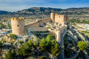 İspanya 'nın Valencia eyaletindeki Castalla Kalesi' nin havadan görünüşü. Donjon şehrin üzerinde yükseliyor ve güneşli bir günde mavi gökyüzü planının yapıldığı dairesel bir kuleyle güçlendirilmiş bir avlu var.