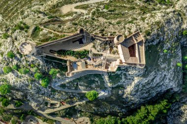 İspanya 'nın Valencia eyaletindeki Castalla Kalesi' nin havadan görünüşü. Donjon şehrin üzerinde yükseliyor ve güneşli bir günde mavi gökyüzü planının yapıldığı dairesel bir kuleyle güçlendirilmiş bir avlu var.