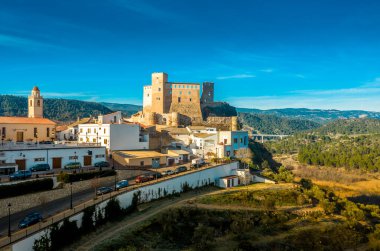 İspanya 'daki Cabriel nehrinin üzerinde kısmen restore edilmiş ortaçağ kalesinin hava panoramik manzarası yansıması ve dramatik gökyüzü ile