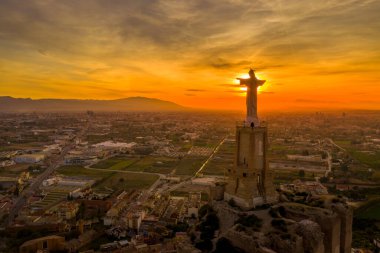 Monteagudo kalesinin hava günbatımı görüntüsü, Murcia İspanya yakınlarındaki dağın şeklini takip eden iki kaplamayla birlikte, çarpık topraktan inşa edilmiş. 
