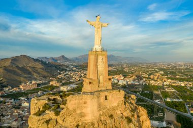 Monteagudo kalesinin hava günbatımı görüntüsü, Murcia İspanya yakınlarındaki dağın şeklini takip eden iki kaplamayla birlikte, çarpık topraktan inşa edilmiş. 