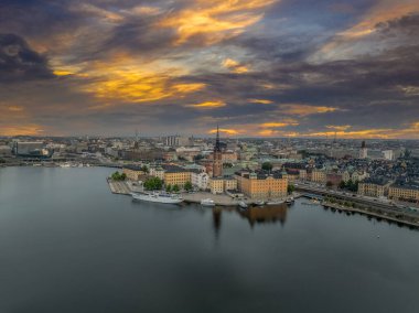 Stockholm 'deki Old Town Gamla Stan' in hava manzarası. Küçük bir ada, belediye binası, dramatik gün batımı gökyüzü olan su yolları.