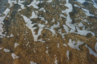 Sörf, dalga, alt, küçük çakıl taşları, temiz su, dalgalardan gelen ılık deniz köpüğü.