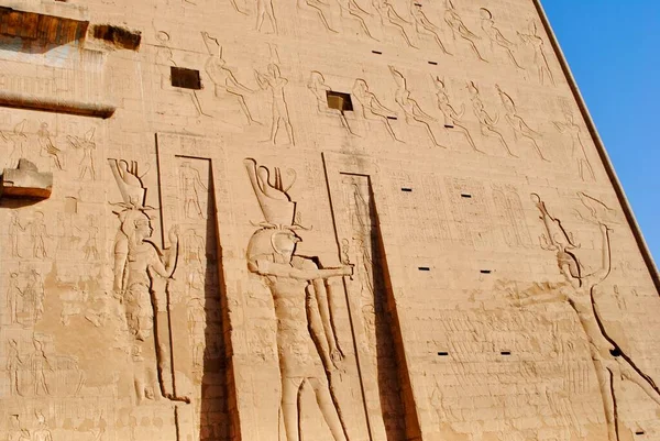 The relief of the entrance of Temple of Horus, Sky God, depicted as a falcon-headed man. Edfu, West bank of the Nile, Aswan Egypt.