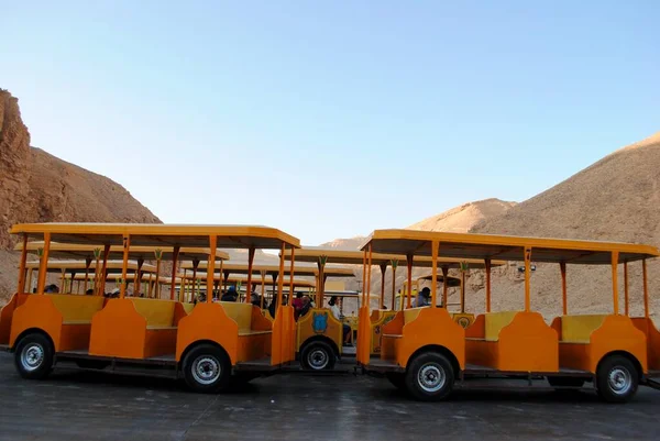 Luxor Egipto. Passeios turísticos trolly amarelo com turistas a bordo do Vale dos Reis, túmulos para os faraós e nobres poderosos datado do século 16 aC. Património Mundial da UNESCO. — Fotografia de Stock