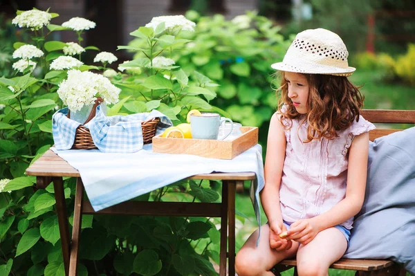 背景にアジサイの花を咲く咲く庭の暖かい夏の日を楽しむ帽子で幸せな子供女の子 — ストック写真