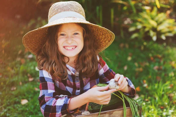 幸せな農家の子女の子が木箱に秋の収穫を選ぶします 有機ニンニク ニンジン カボチャ ズッキーニの野菜の庭成長 — ストック写真