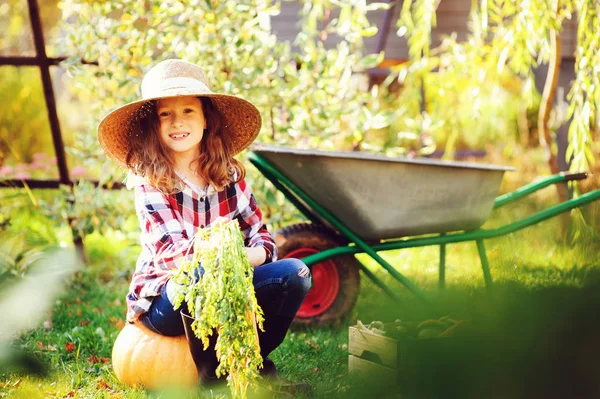 庭で野菜収穫の秋を選んで幸せな農家の子供女の子 有機にんじん カボチャを成長 — ストック写真