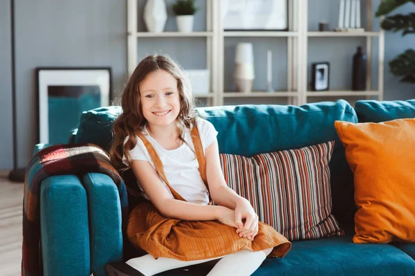 Dziewczyna Szczęśliwy Wesoły Dzieciak Siedzi Przytulnej Kanapie Nowoczesnym Salonie Zakup — Zdjęcie stockowe