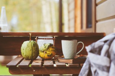 sonbahar sabahı rahat kır evi, fincan çay ve sıcak bir battaniye ahşap masa var. Natürmort ayrıntıları