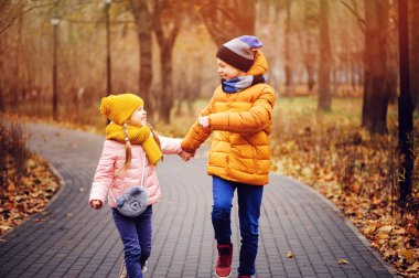 ve mutlu erkek kardeşim yolun güneşli Park'ta yürüyordunuz sonbahar portresi. Birlikte sıcak gün açık oynayan çocuklar.