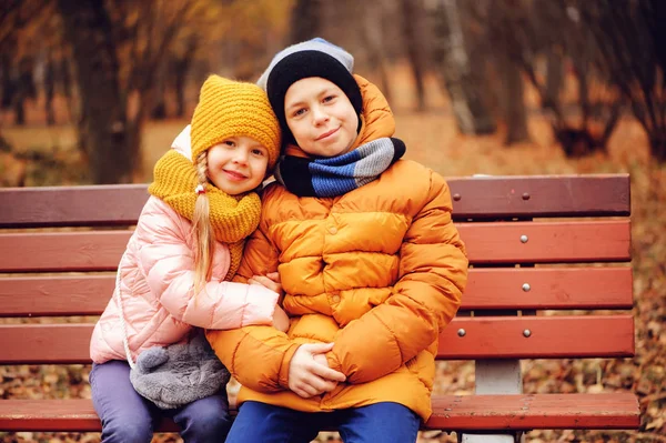 Outono Retrato Crianças Felizes Irmão Irmã Sentados Banco Parque Abraços — Fotografia de Stock