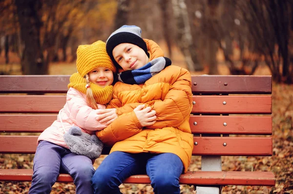 Retrato Otoño Niños Felices Hermano Hermana Sentados Banco Parque Abrazos — Foto de Stock