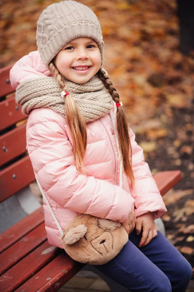 Осенний Портрет Улыбающейся Девочки Сидящей Скамейке Парке Теплой Вязаной Шляпе — стоковое фото