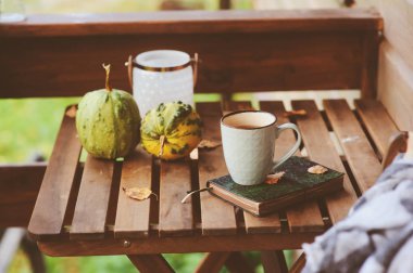 sonbahar sabahı rahat kır evi, fincan çay ve sıcak bir battaniye ahşap masa var. Natürmort ayrıntıları