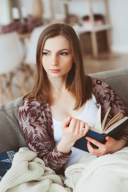 ilginç kitap, modern iç rahat kanepede oturan ile hafta sonu evde reaxing genç düşünceli kadın kapalı portresi