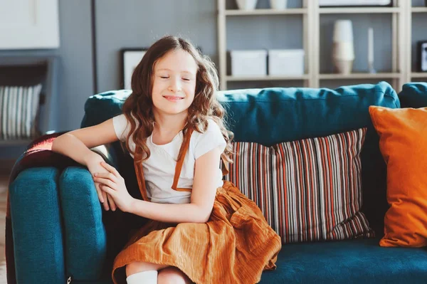 快乐开朗的女孩坐在舒适的沙发在现代客厅 购买新家 搬到大公寓 租房概念 — 图库照片