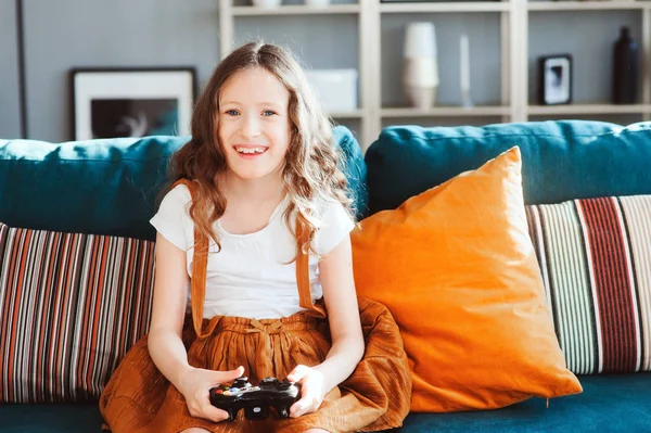 video oyunları evde, gamepad ile modern iç rahat koltukta oturan oynayan mutlu çocuk